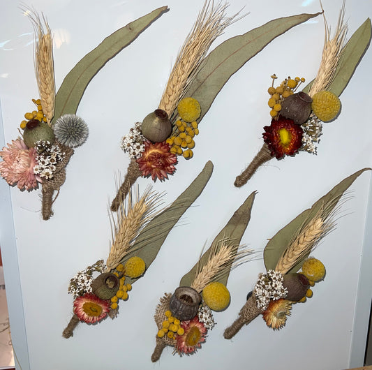 Set of dried flower and leaf boutonnieres on a white background