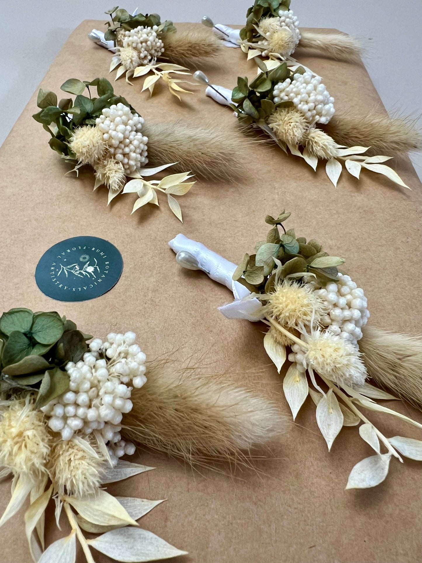 Decorative floral arrangements on a textured surface with a visible brand logo.