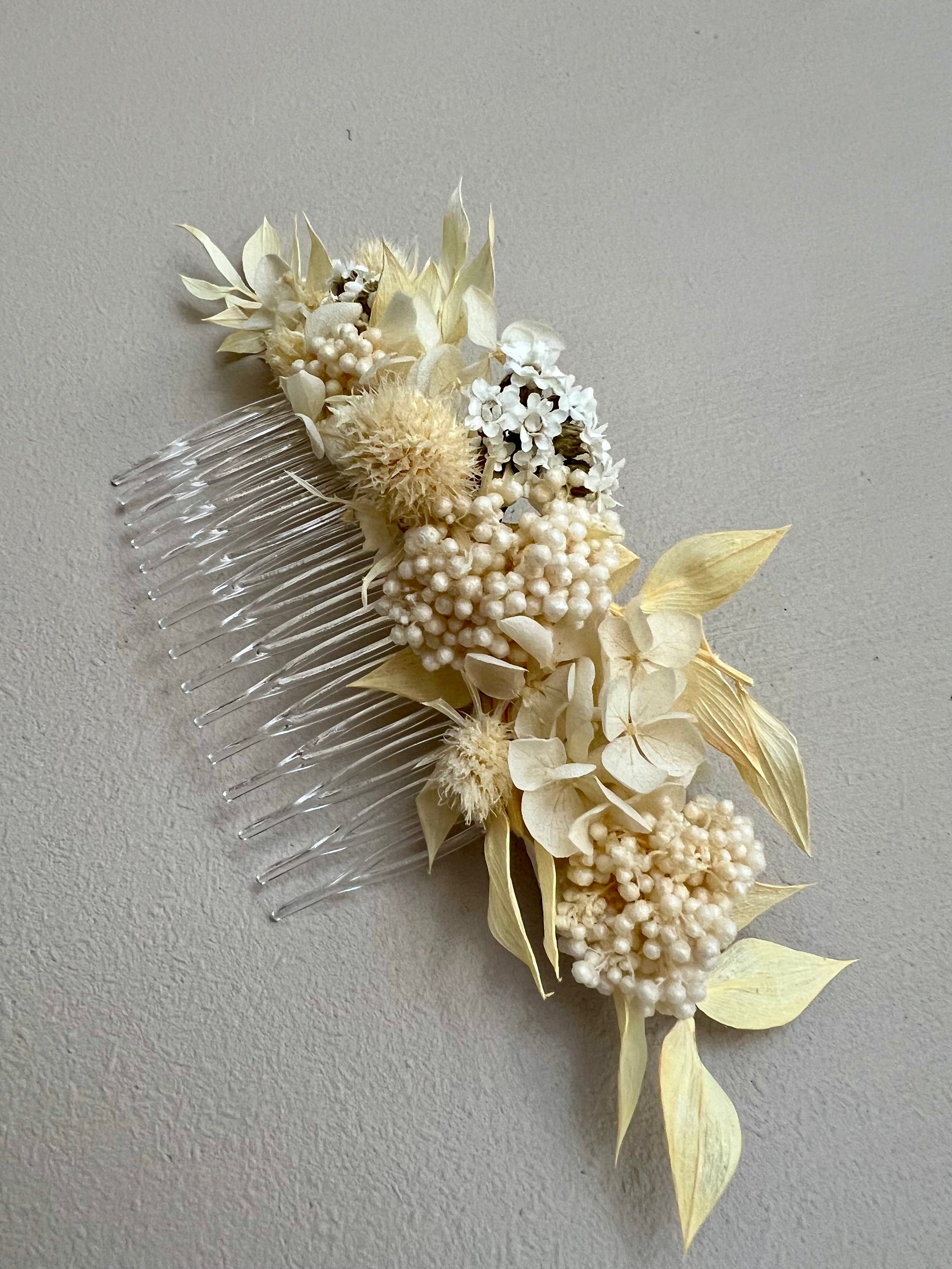 Decorative hair comb with flowers and pearls on a gray background