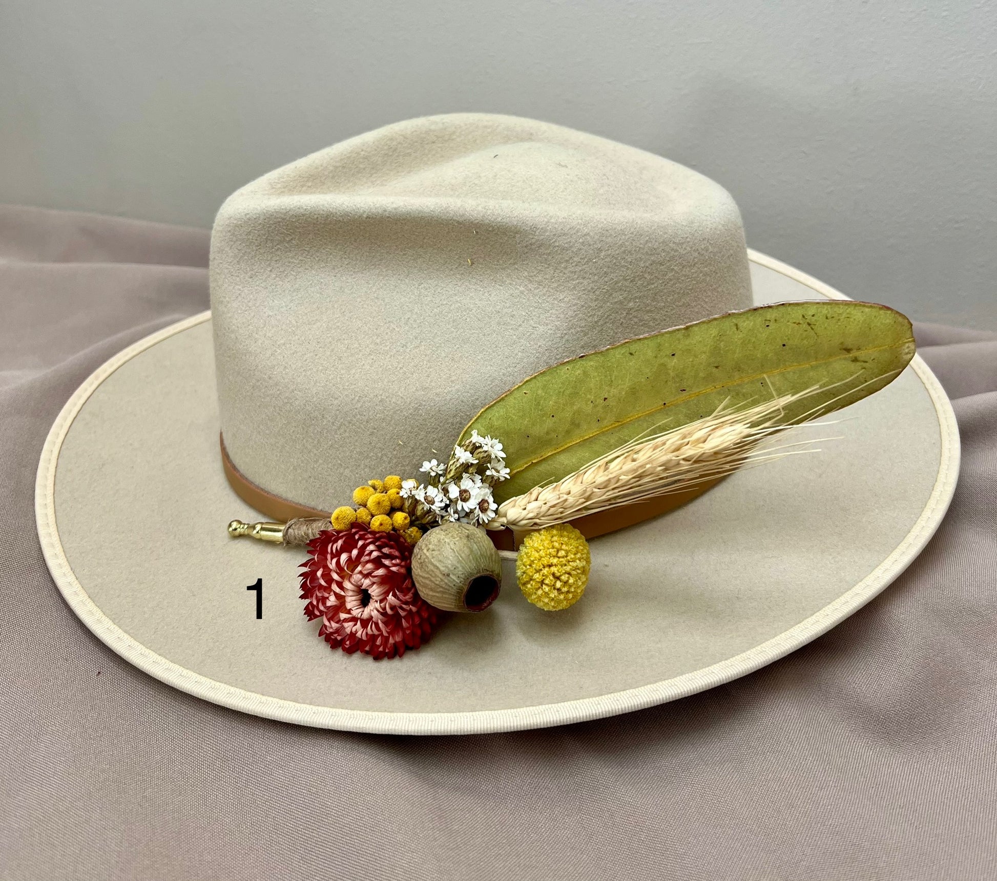 Beige hat with decorative elements on a gray background