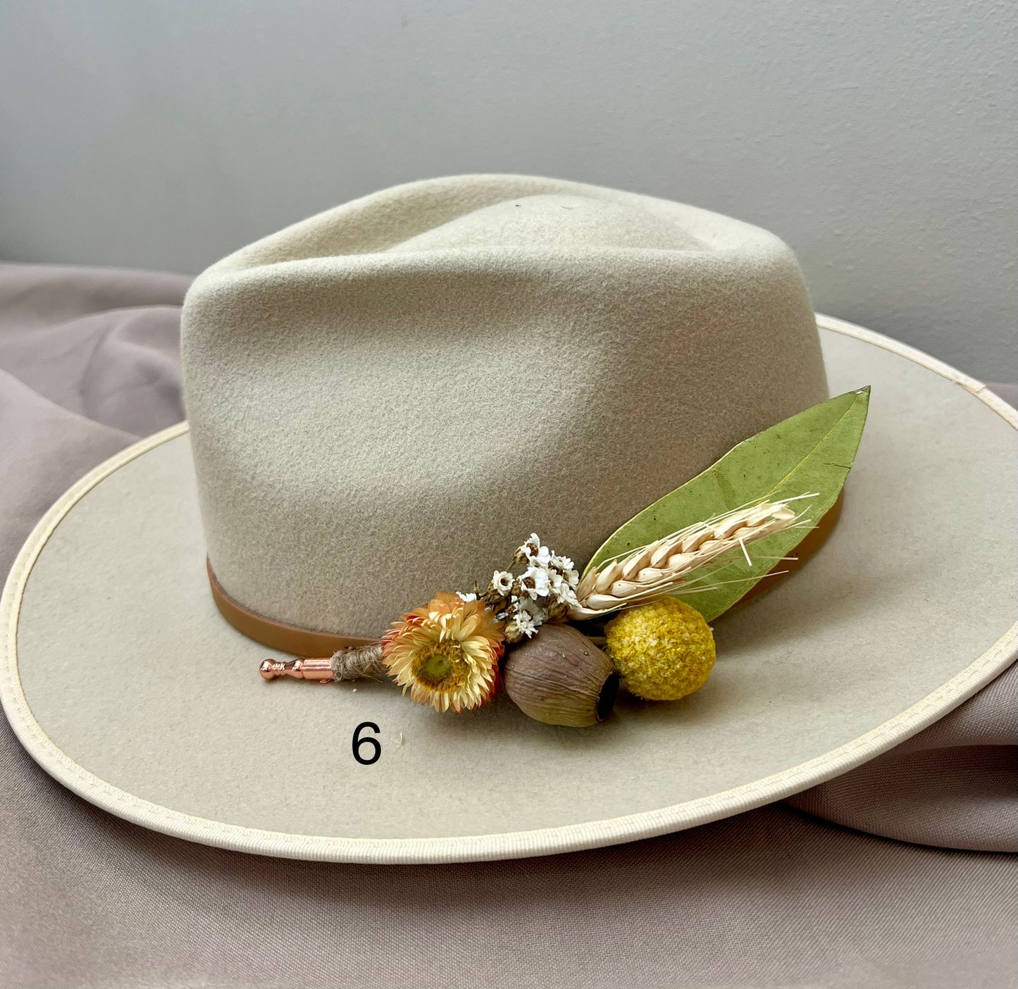 Beige hat with decorative elements on a gray background