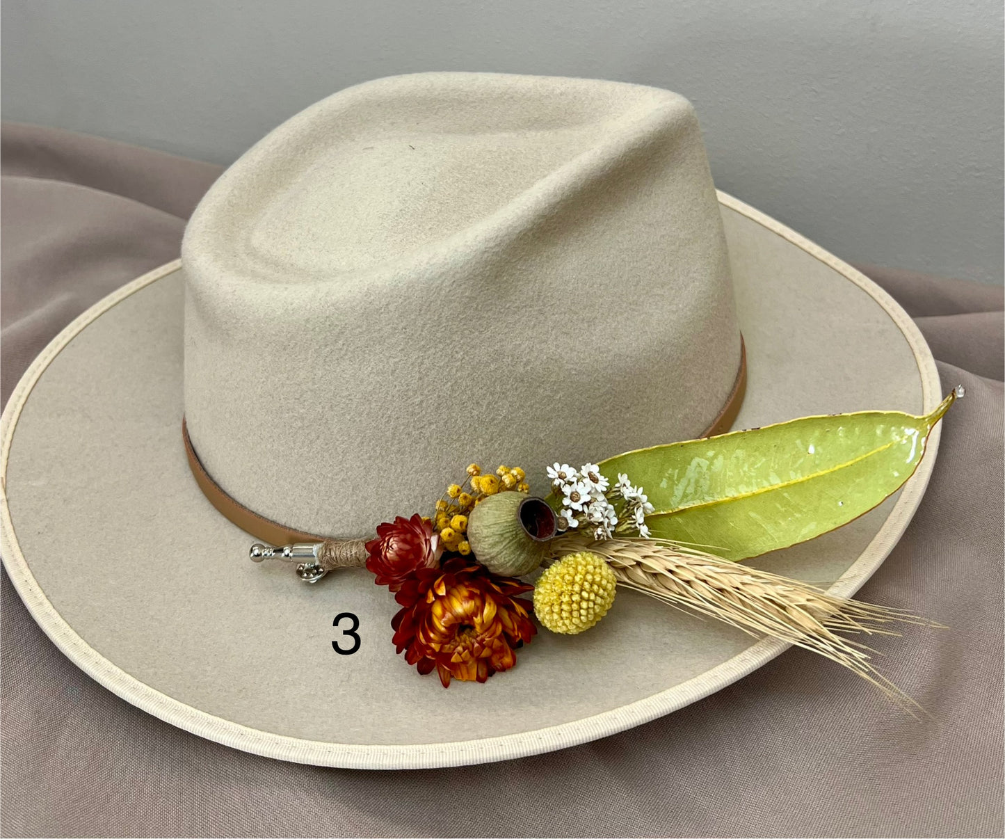 Beige cowboy hat with decorative elements on a gray background