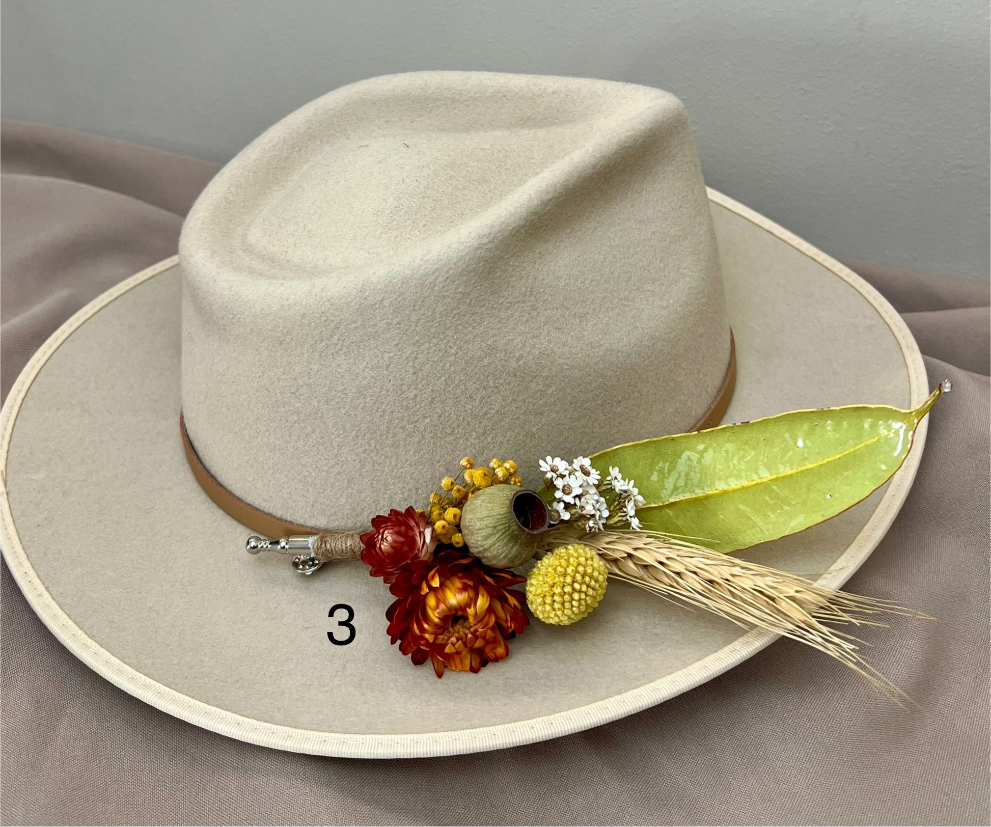 Beige cowboy hat with decorative elements on a gray background