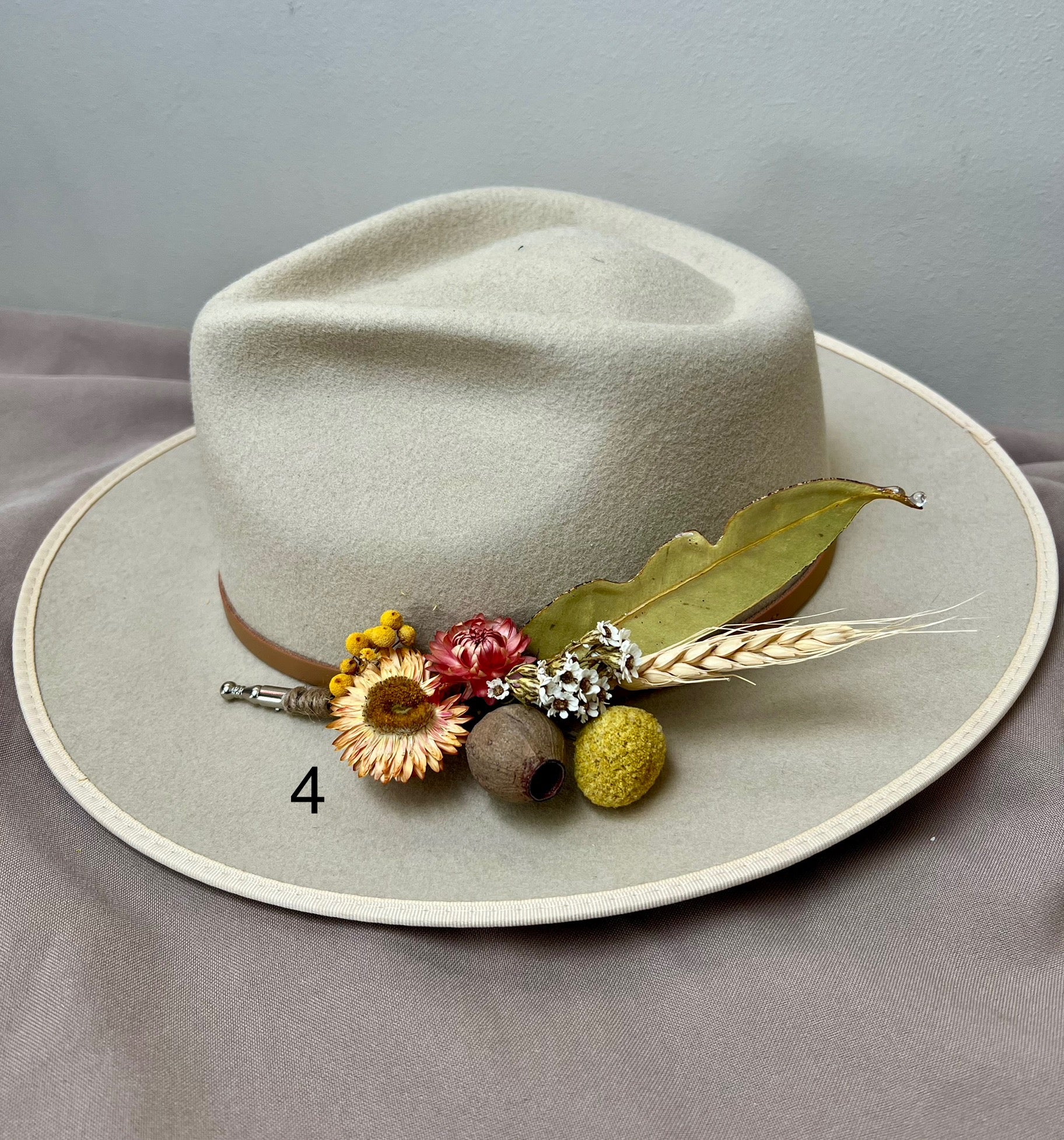 Light-colored hat with decorative elements on a gray background