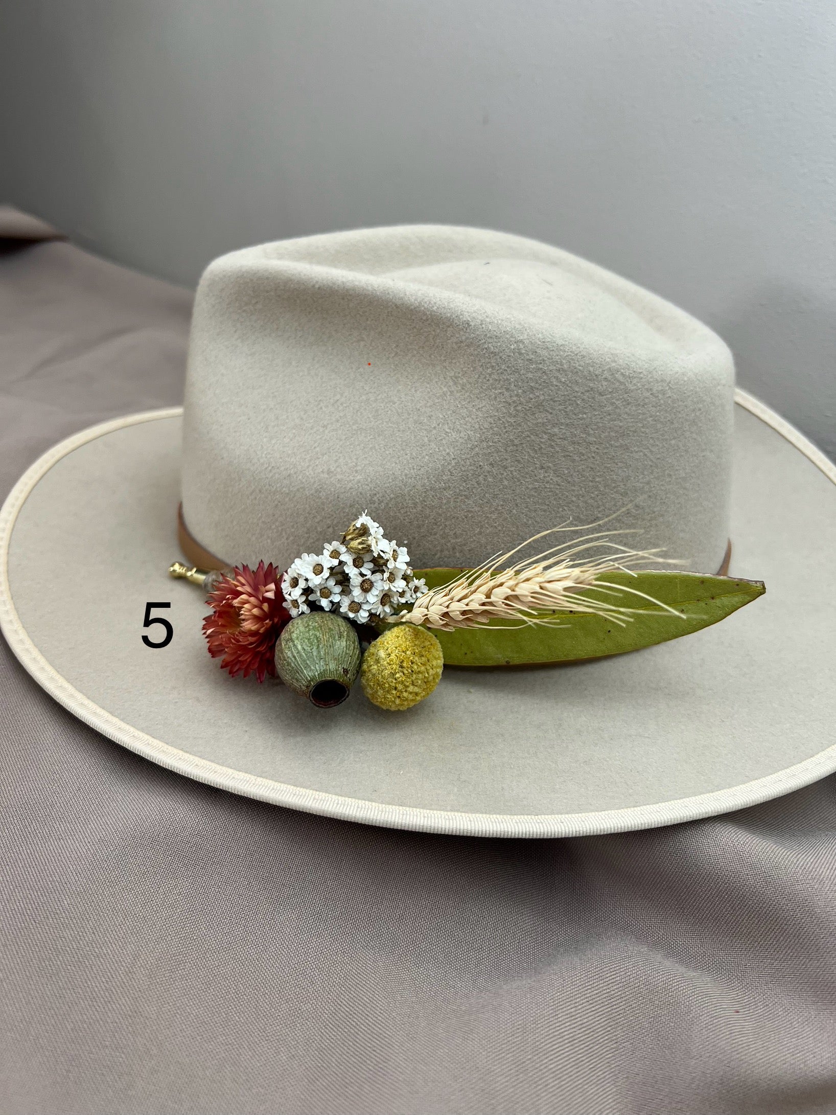 Light gray hat with decorative elements on a gray background