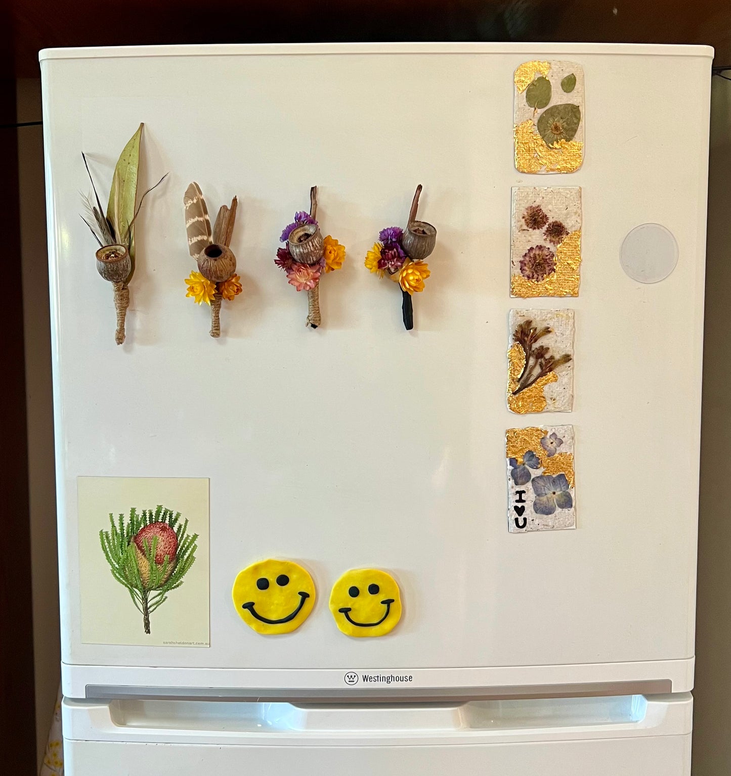 Decorative magnets on a refrigerator door with nature-themed designs.