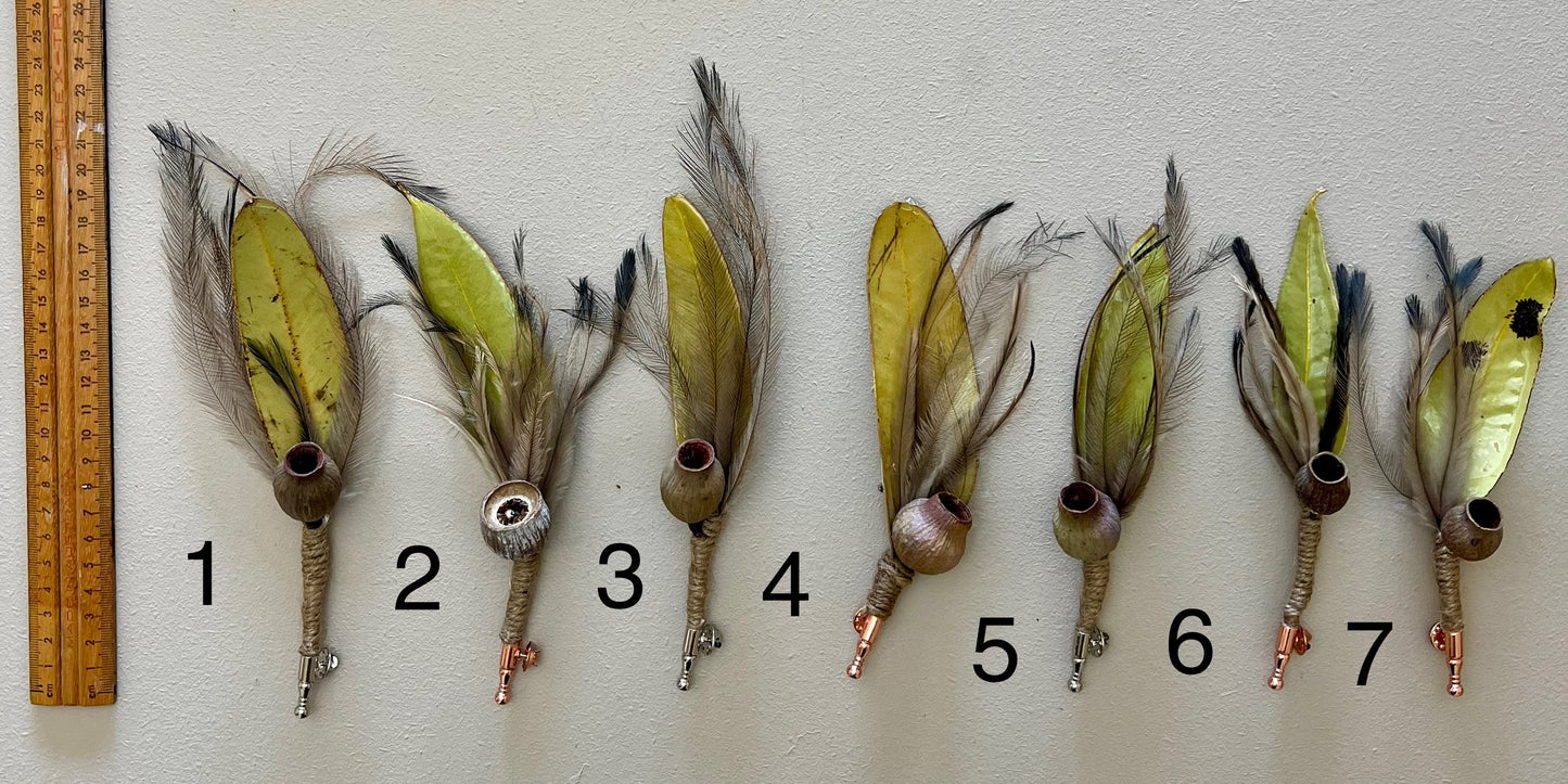 Seven feathered fishing lures with a ruler for scale on a white background