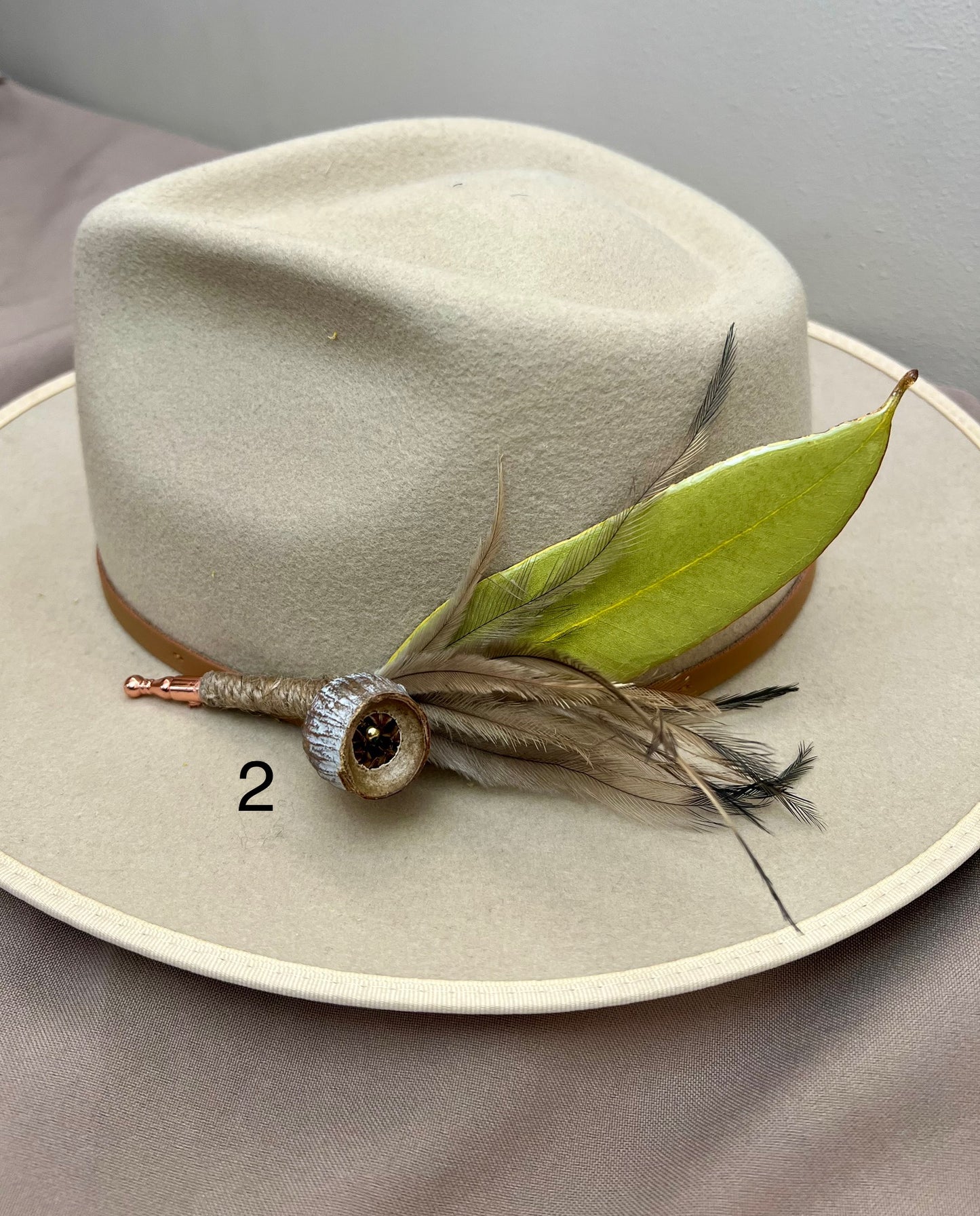 Beige hat with decorative elements on a gray background